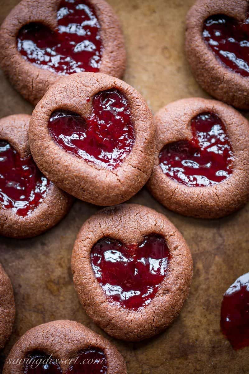 Chocolate Raspberry Thumbprint Cookies - who can resist the classic combination of raspberries and chocolate?! This little chocolate cookie boasts plenty of chocolate flavor and a fun little heart shaped thumbprint filled with seedless raspberry jam. An easy and delicious cookie with a Valentine's Day theme for your sweetie! www.savingdessert.com