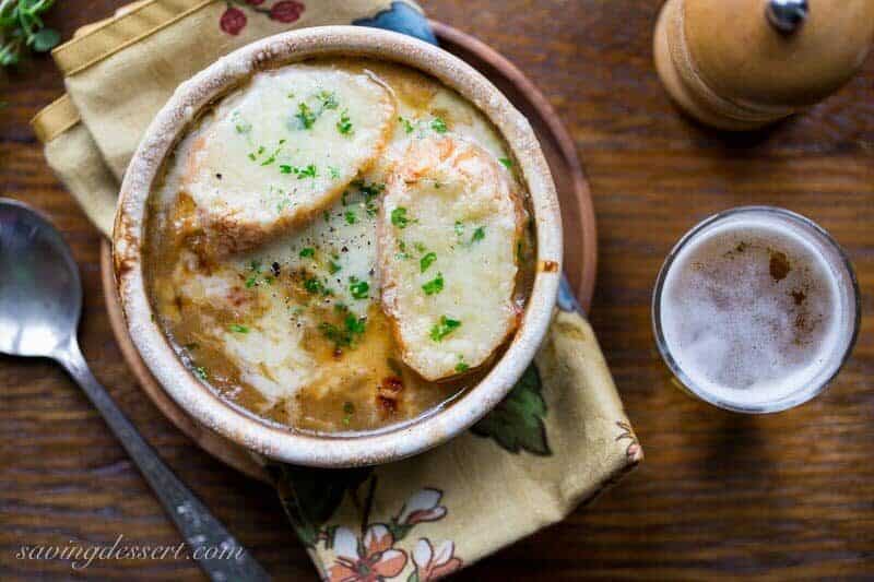 French Onion Soup loaded with sweet caramelized onions, fresh thyme, beef stock and a big splash of pale lager, then topped with toasted garlic croutons and plenty of strong Gruyère cheese. Oh my this is good! www.savingdessert.com