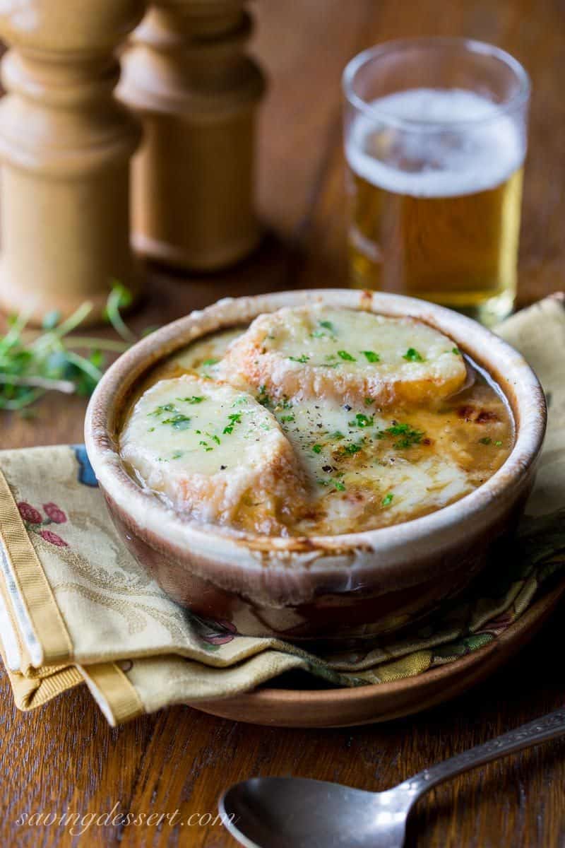 French Onion Soup loaded with sweet caramelized onions, fresh thyme, beef stock and a big splash of pale lager, then topped with toasted garlic croutons and plenty of strong Gruyère cheese. Oh my this is good! www.savingdessert.com