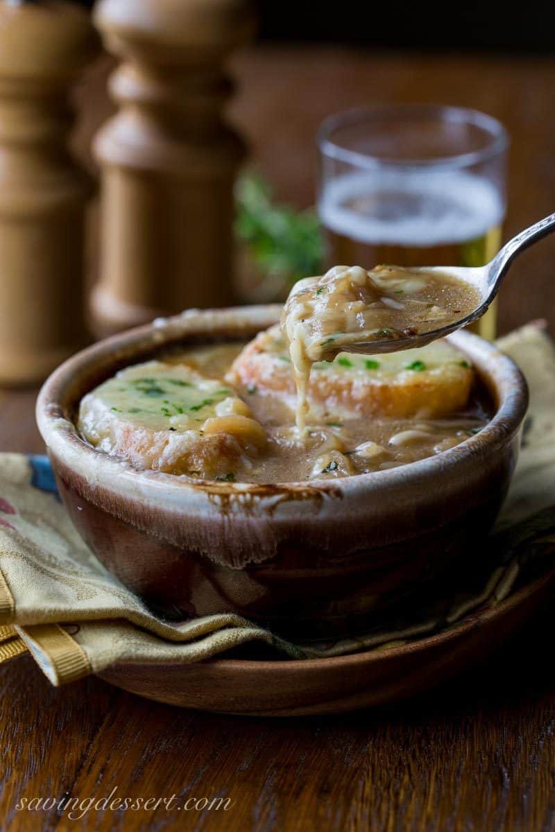 French Onion Soup loaded with sweet caramelized onions, fresh thyme, beef stock and a big splash of pale lager, then topped with toasted garlic croutons and plenty of strong Gruyère cheese. Oh my this is good! www.savingdessert.com