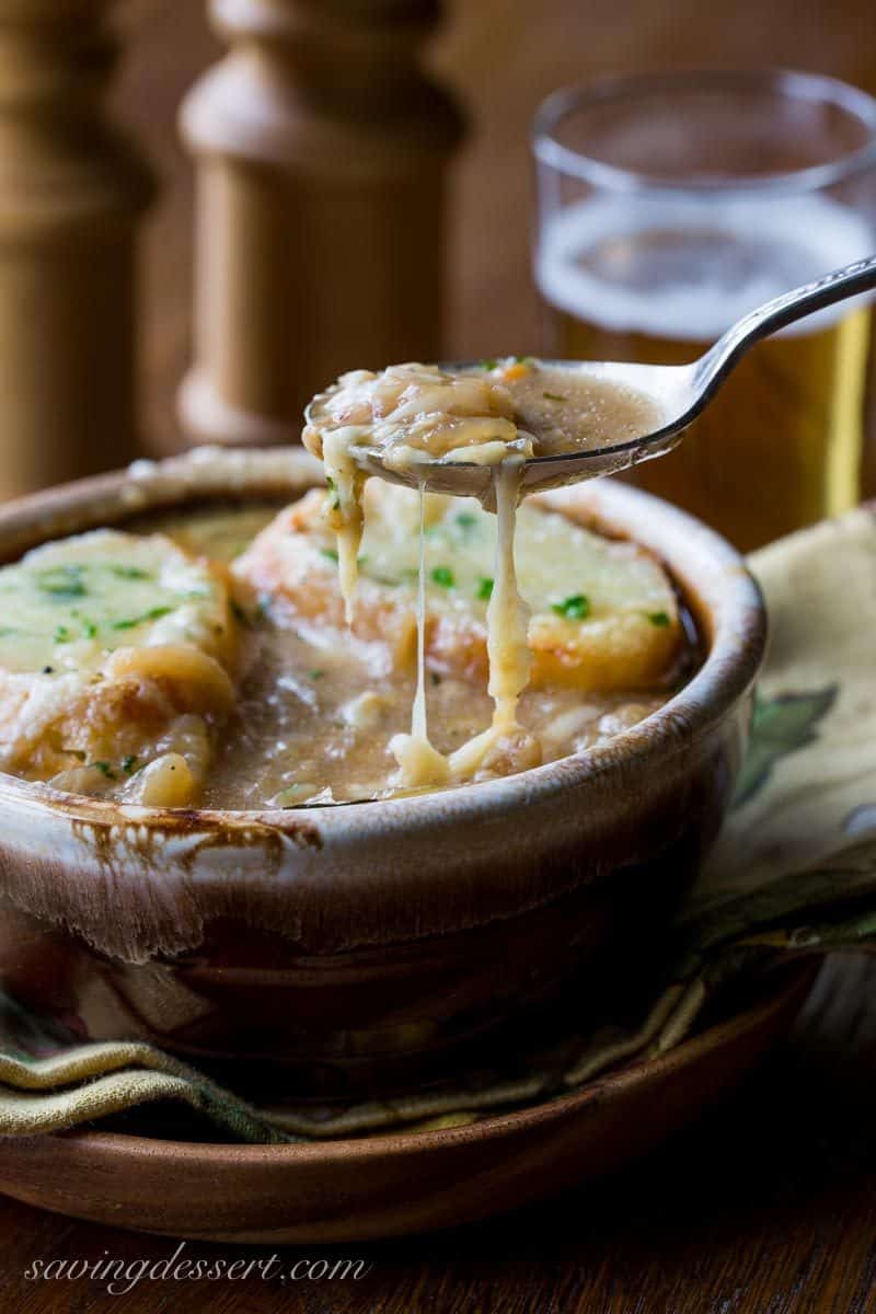 French Onion Soup loaded with sweet caramelized onions, fresh thyme, beef stock and a big splash of pale lager, then topped with toasted garlic croutons and plenty of strong Gruyère cheese. Oh my this is good! www.savingdessert.com