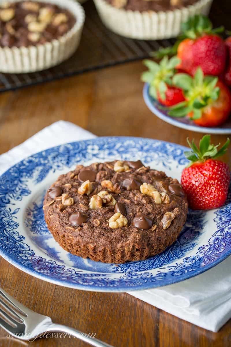 Healthy Chocolate Muffins ~ with no added sugar! Loaded with spelt flour, oats, ground flaxseed meal, and coconut oil, and sweetened with applesauce and honey. Topped with dark chocolate chips and chopped walnuts. DELICIOUS! www.savingdessert.com