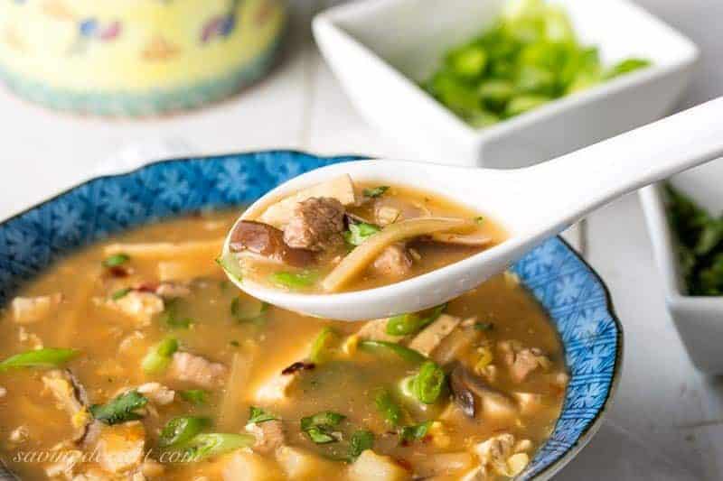 A spoonful of hot & sour soup over a bowl