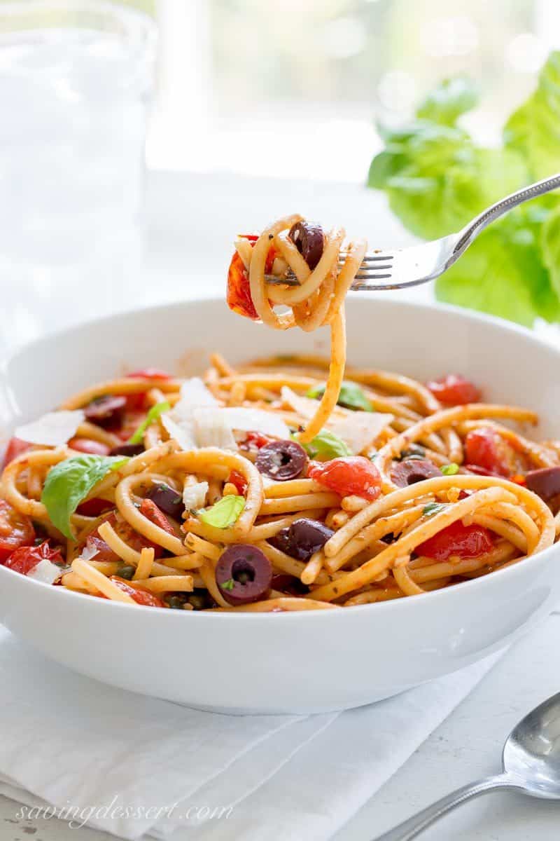 Bucatini Puttanesca ~ a deliciously easy one-pot pasta dish with a simple but zesty sauce and loads of fresh tomatoes, olives and capers. www.savingdessert.com anchovy | red pepper | bucatini pasta | spaghetti | cherry tomatoes | kalamata olives | capers | meatless monday