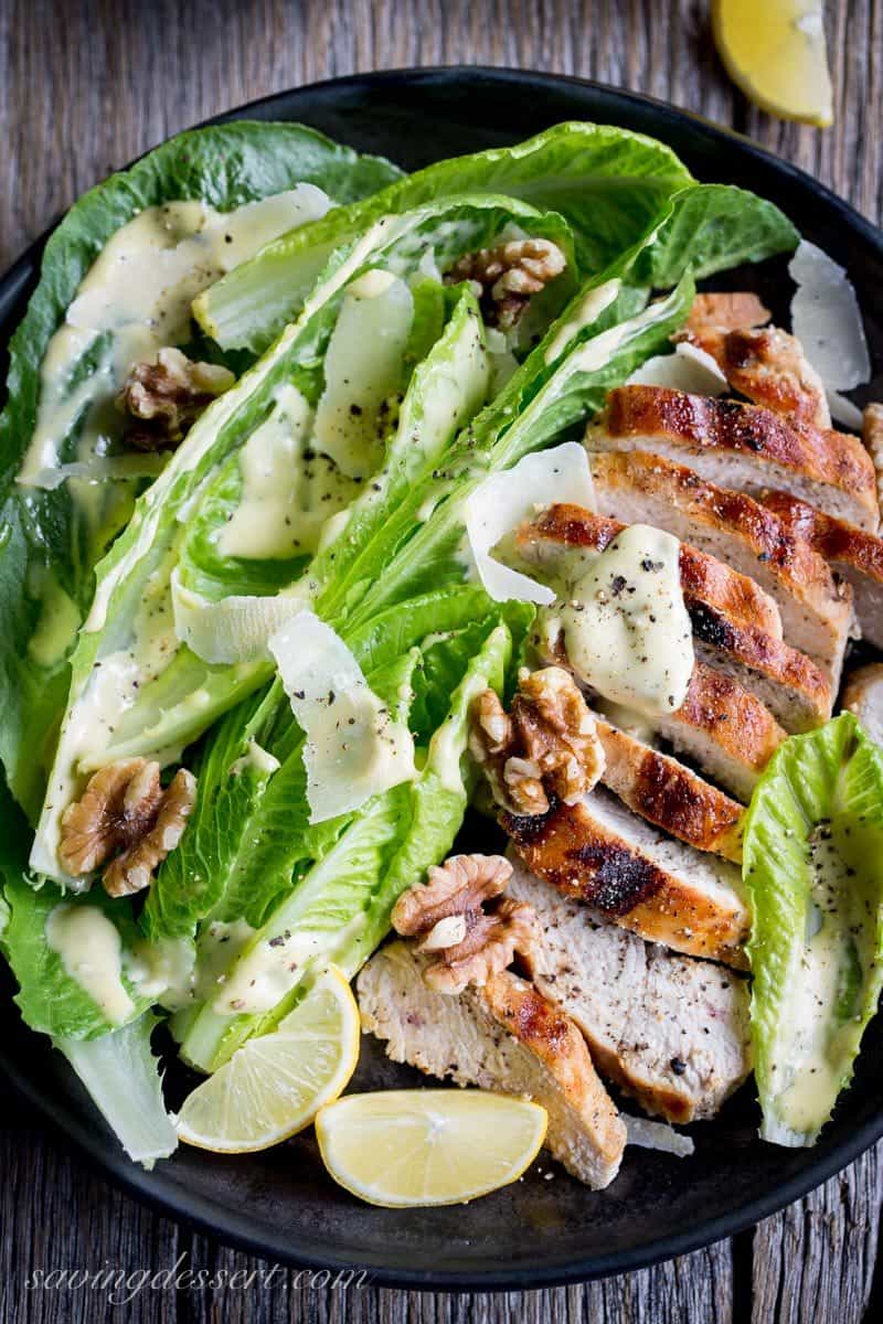 Grilled Chicken Caesar Salad ~ an easy homemade Caesar dressing is drizzled over tender grilled chicken and hearts of romaine lettuce, then topped with shaved Parmesan, plenty of fresh ground black pepper and toasted walnuts. This main dish salad is sure to please your salad loving family! www.savingdessert.com