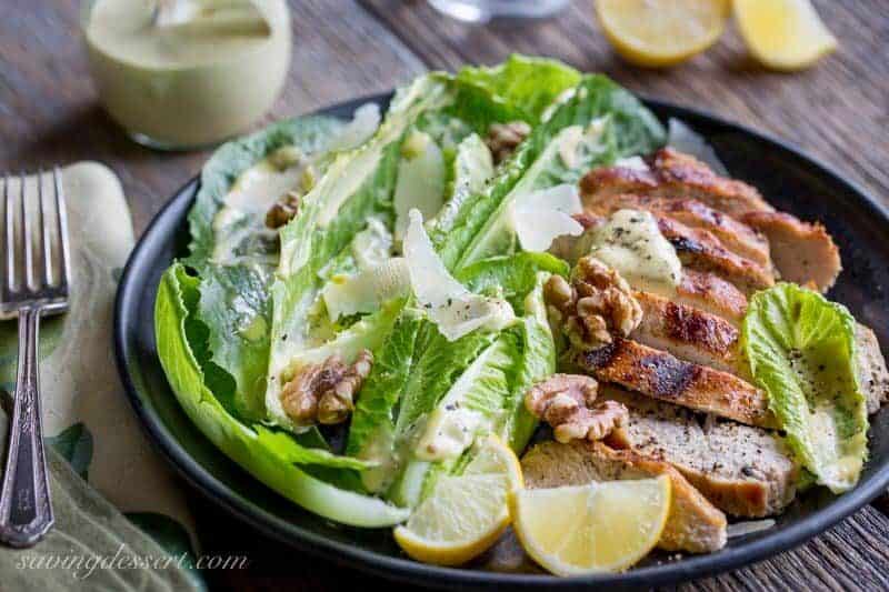 Grilled Chicken Caesar Salad ~ an easy homemade Caesar dressing is drizzled over tender grilled chicken and hearts of romaine lettuce, then topped with shaved Parmesan, plenty of fresh ground black pepper and toasted walnuts. This main dish salad is sure to please your salad loving family! www.savingdessert.com
