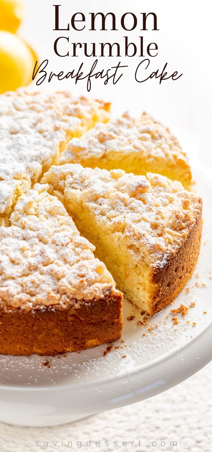 Lemon Crumble Breakfast Cake dusted with powdered sugar on a cake stand 