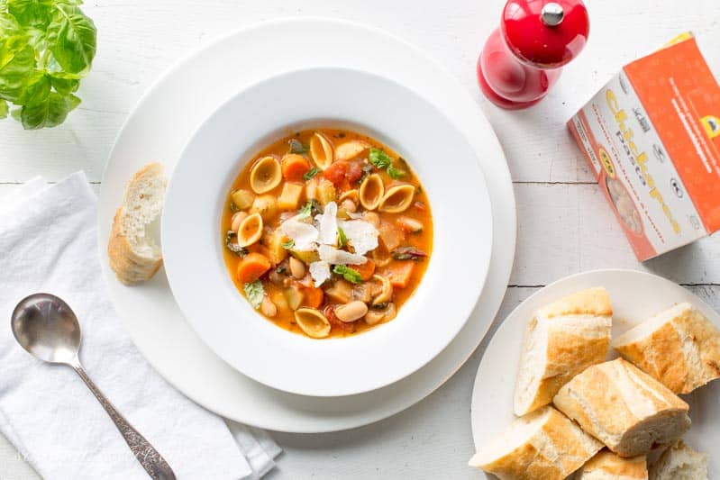 An overhead view of a bowl of Winter Minestrone soup with fresh Baguette on the side