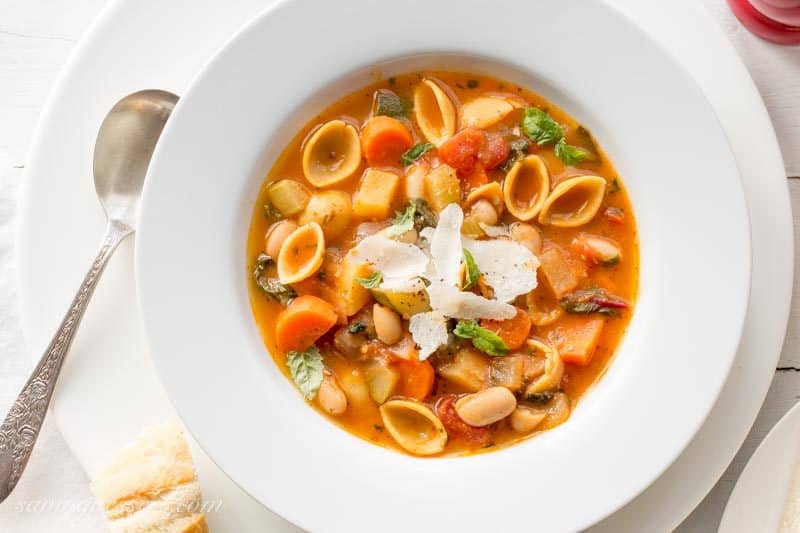 A bowl of winter minestrone soup with beans, greens, carrots and fresh herbs