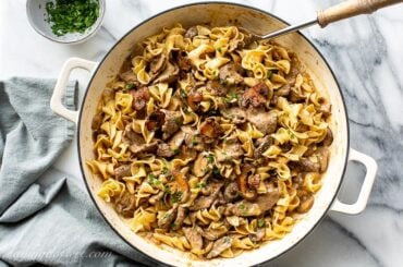 Overhead view of a casserole pan filled with sliced beef, egg noodles, mushrooms in a rich gravy