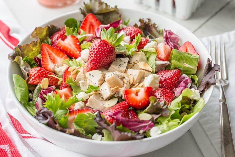 Simple and light, and deliciously refreshing ~ Strawberry Salad with Chicken and Poppy Seed Dressing is a great main course salad with an amazing combination of flavors. From the tender chunks of chicken and the creamy bite of feta cheese, to the toasted sliced almonds and poppy seeds, every bite will delight your senses! www.savingdessert.com