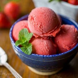 A bowl filled with fresh strawberry sorbet and mint leaves