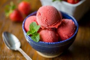 A bowl filled with fresh strawberry sorbet and mint leaves