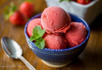 A bowl filled with fresh strawberry sorbet and mint leaves