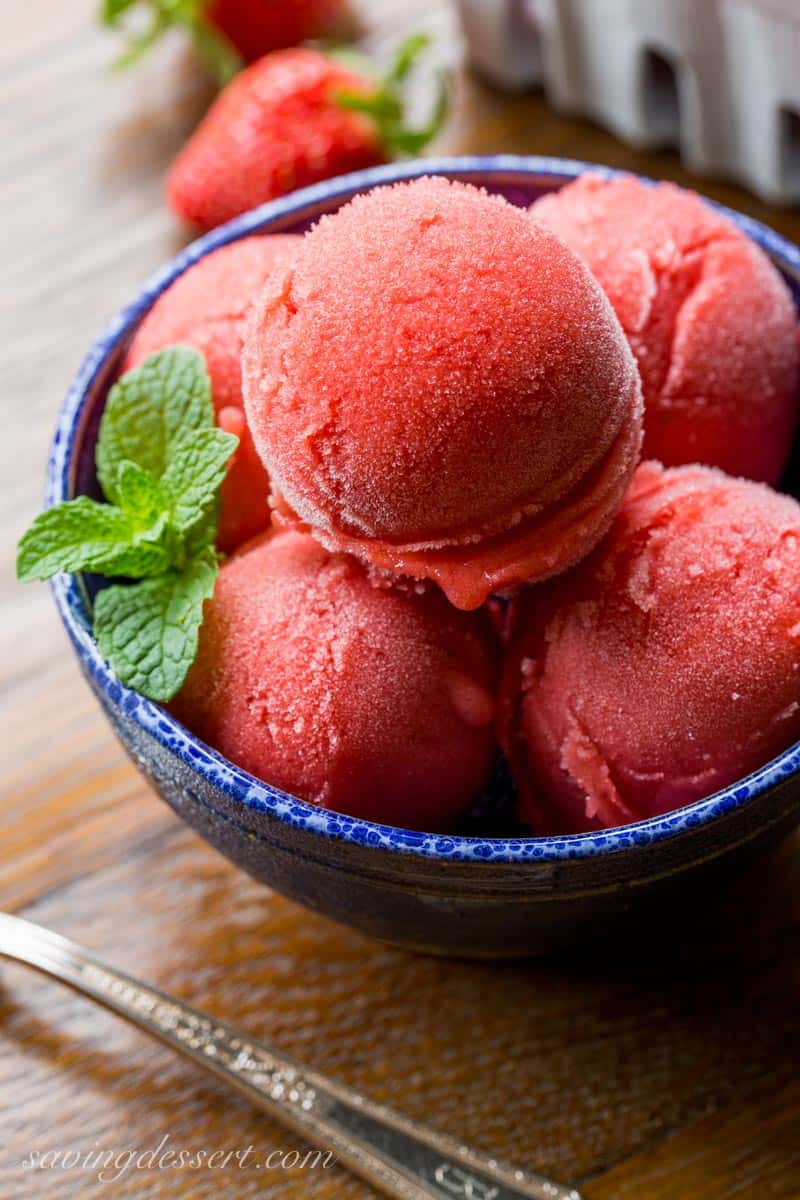 A bowl of strawberry sorbet served with mint leaves