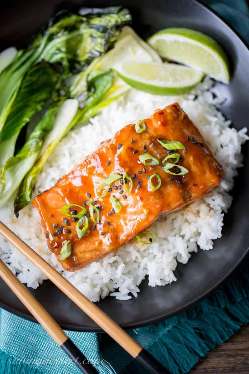 Teriyaki Salmon with green onions and black sesame seeds served on rice with lime and bok choy