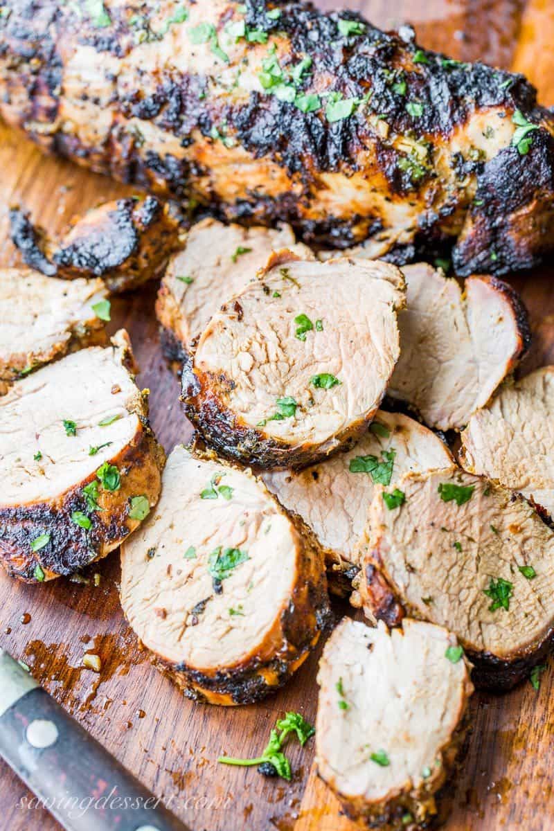 Grilled and sliced Cuban Mojo-Marinated Pork Tenderloin on a cutting board