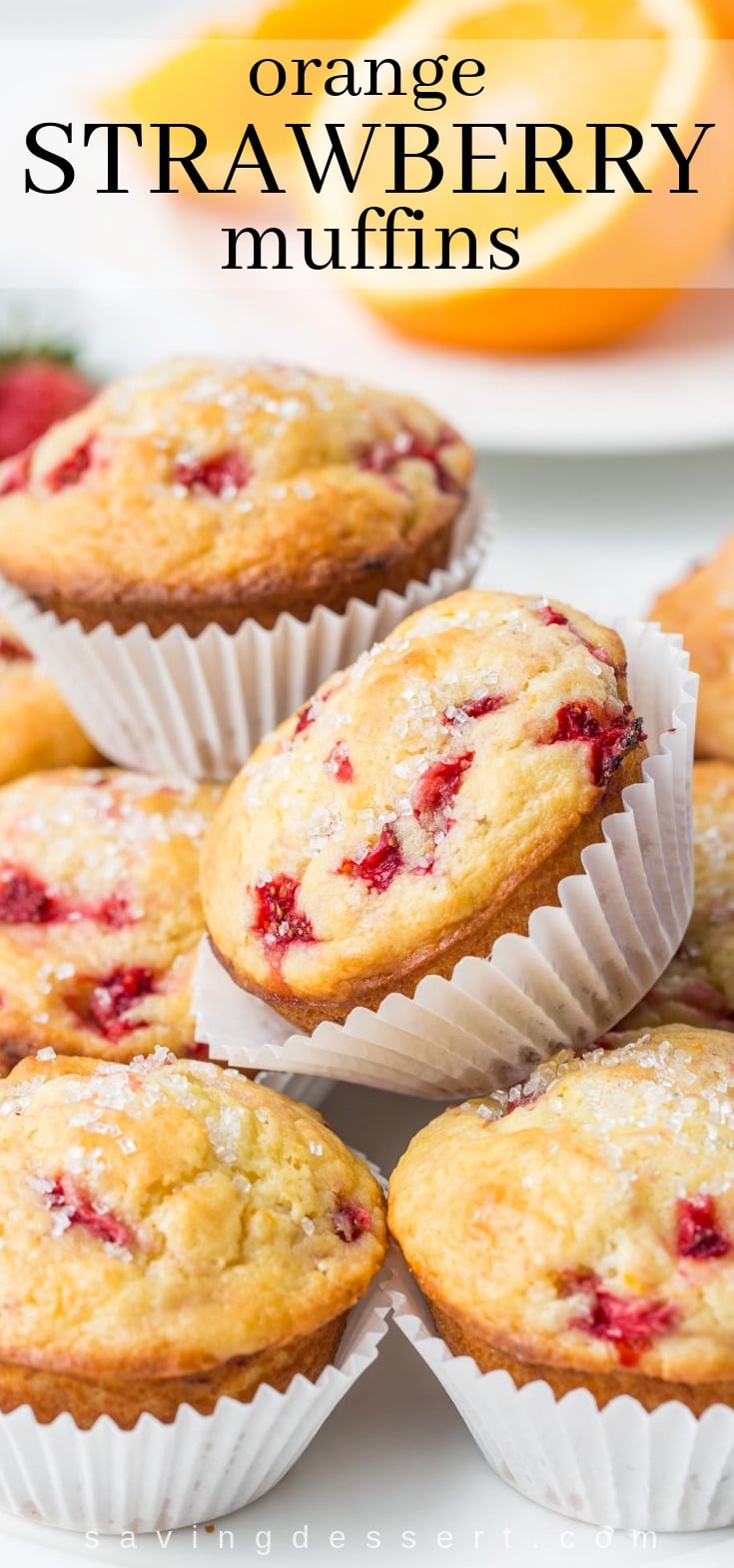 A stack of orange strawberry muffins topped with coarse sugar