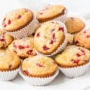 A plate filled with orange strawberry muffins