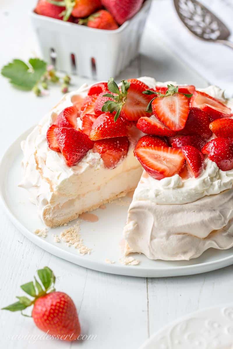 A sliced pavlova topped with mascarpone cream and fresh strawberries