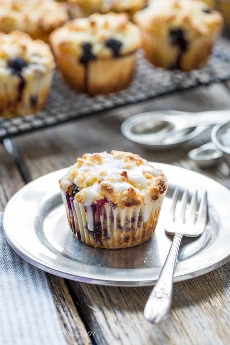 Lemon Blueberry Muffins with a Lemon Crumble Topping ~ Plump, ripe blueberries and tart lemon juice are the stars in these wonderfully moist, sour cream muffins. Not overly sweet, these muffins are terrific with or without the bright lemon glaze. www.savingdessert.com