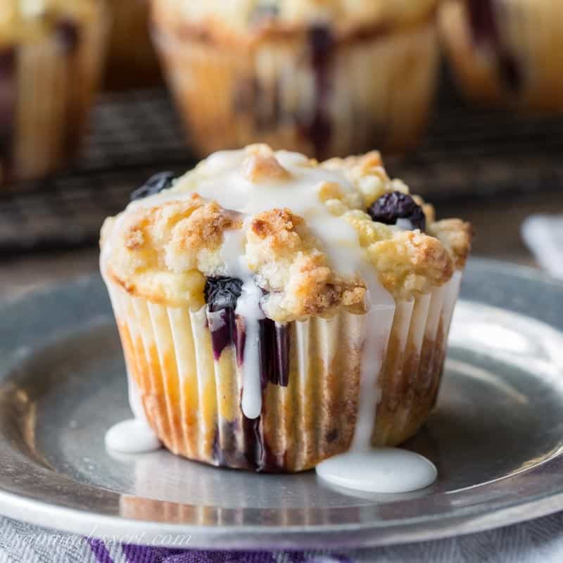 A crumble topped blueberry muffin with a lemon drizzled icing