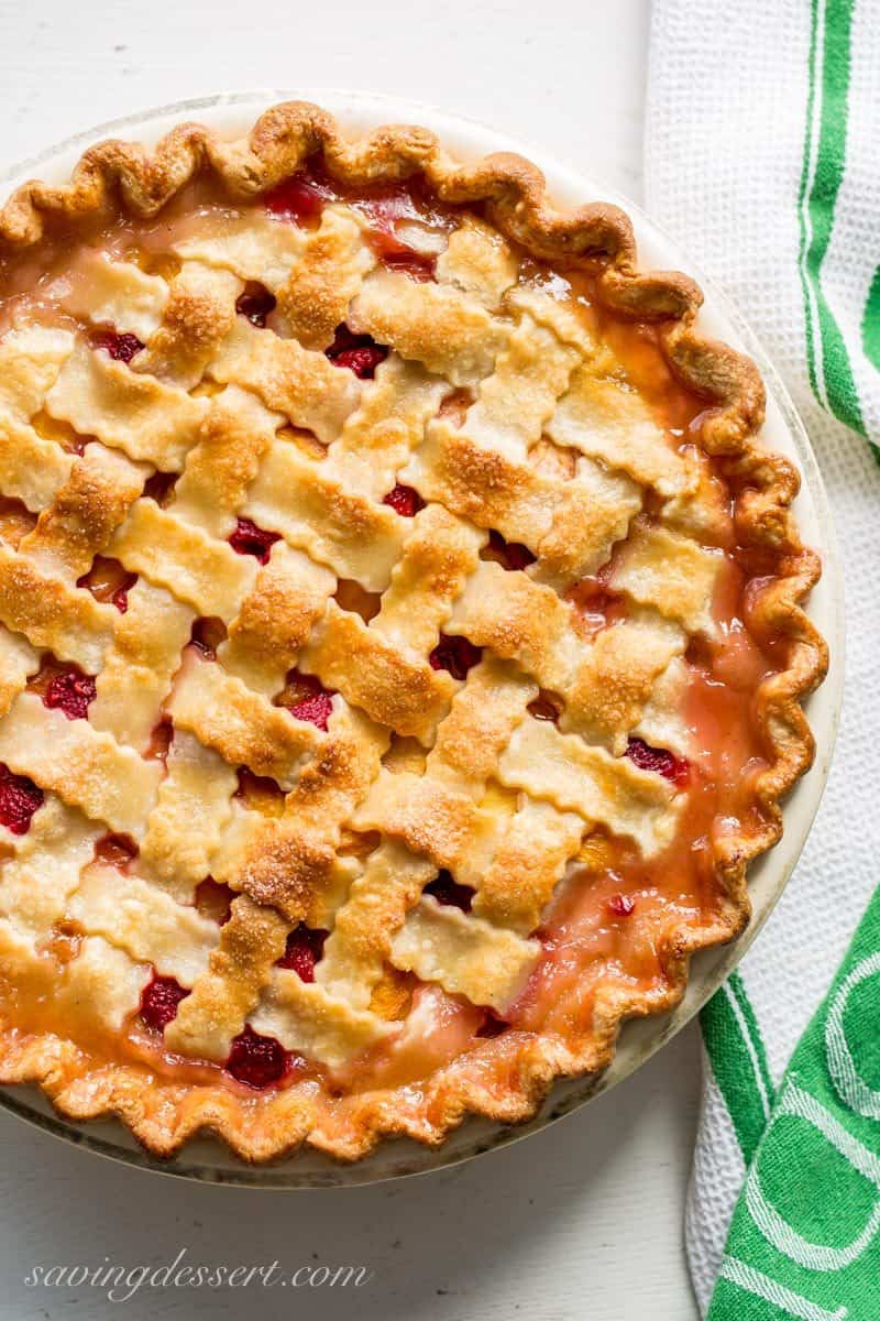 Peach Raspberry Pie with a Lattice Crust ~ juicy, sweet summer peaches are combined with tart raspberries for a wonderful seasonal dessert.  Topped with a flaky, pretty, lattice weaved crust, this pie is a family favorite! www.savingdessert.com