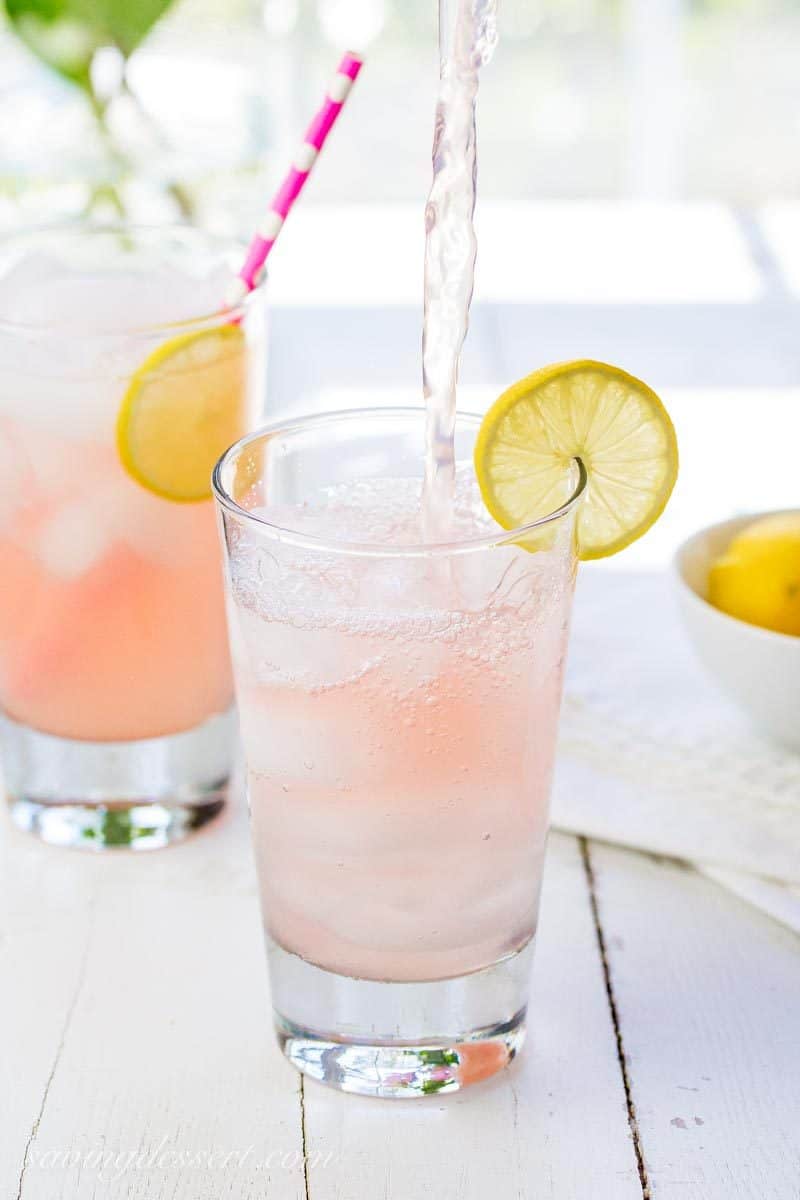 A glass of pink lemonade with a straw