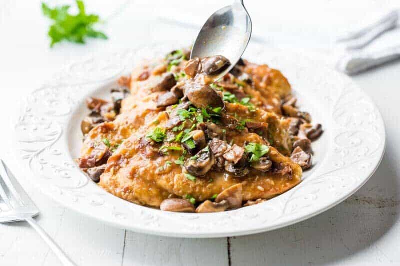 Classic Chicken Marsala ~ tender chicken breasts are seasoned and sautéed, then simmered in a Marsala wine sauce with shallots, prosciutto, and plenty of earthy mushrooms.  Your guests never have to know how easy this is to make! savingdessert.com #chickenmarsala #chickendish #chicken #chickenmushrooms #marsala