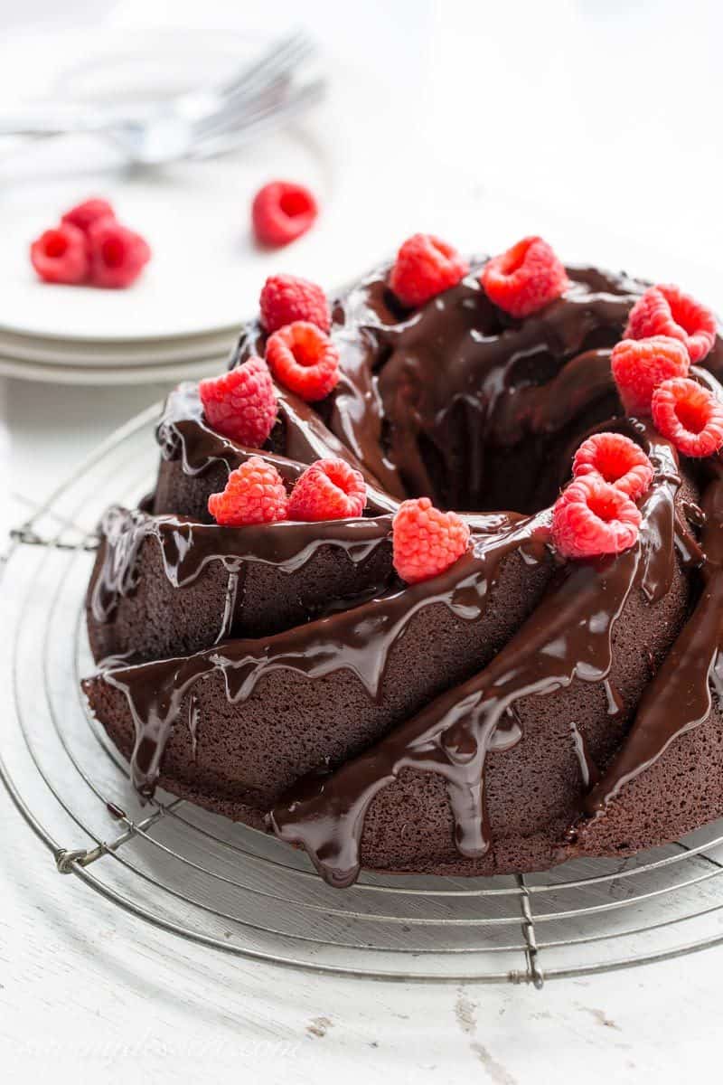 Chocolate Bundt Cake topped with fresh raspberries and a drizzle chocolate ganache icing