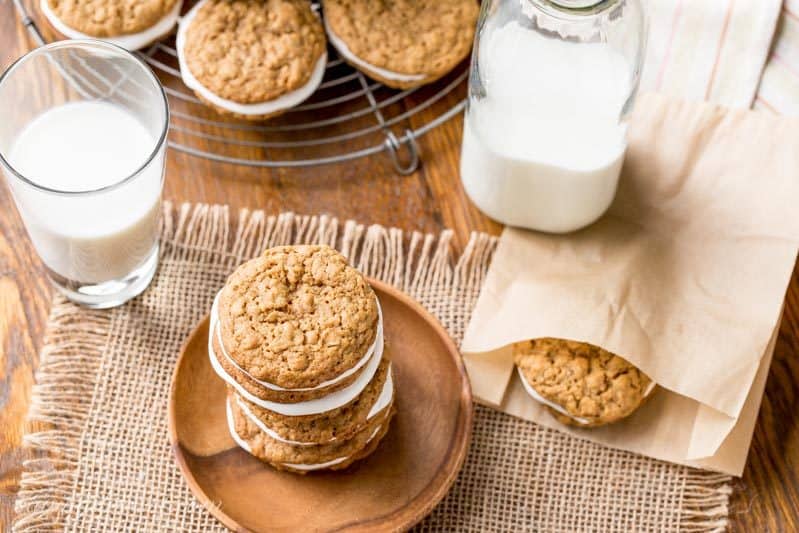 An overhead view of a plate and cooling rack with oatmeal cream pies