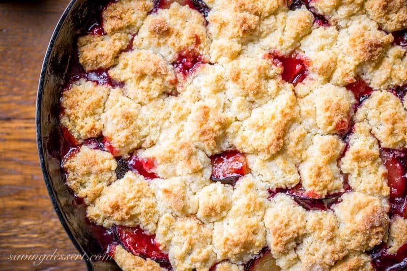 An overhead view of a plum cobbler with a golden brown crust on top