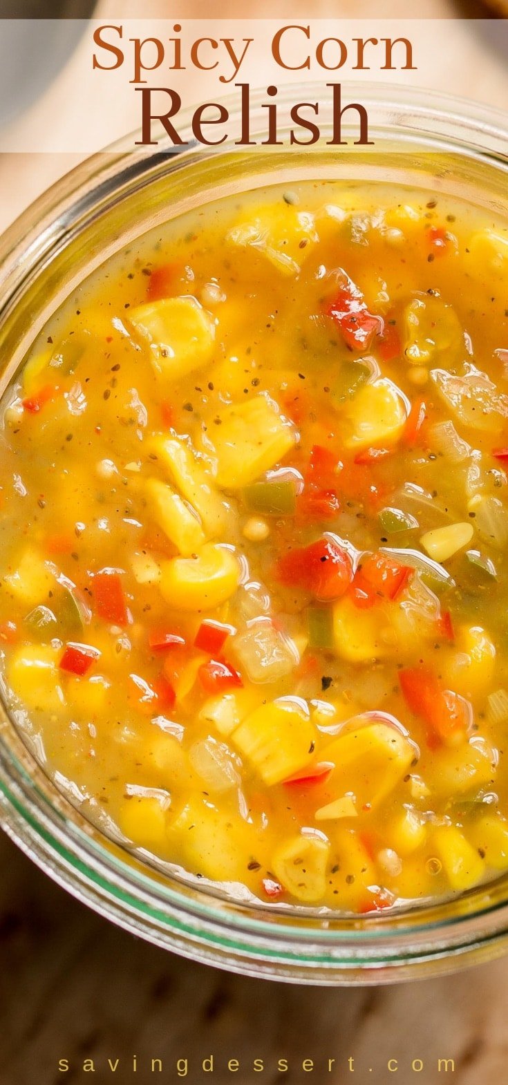 A jar filled with homemade spicy corn relish with red and green peppers