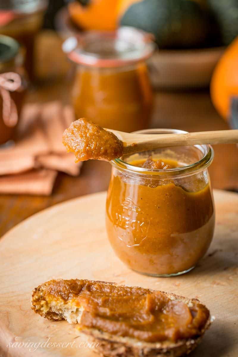 A jar of maple pumpkin butter with a spoonful laid across the top of the jar