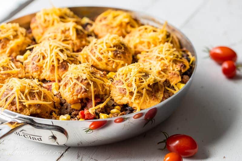 Skillet Taco Cobbler ~ ground beef, black beans, tomatoes and corn come together in a nicely spiced base for our tender, cheesy cornmeal biscuits. www.savingdessert.com #savingroomfordessert #cobbler #taco #tacocobbler #cornmealbiscuits