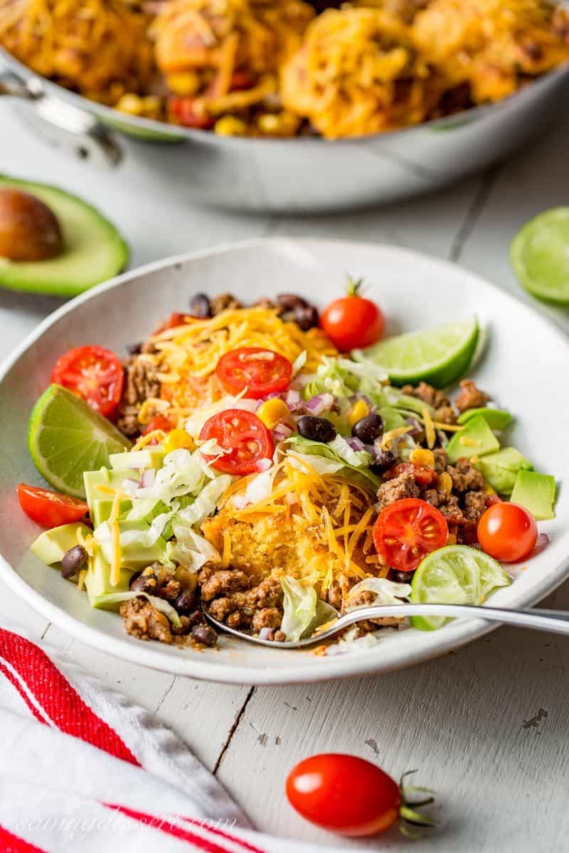 Skillet Taco Cobbler ~ ground beef, black beans, tomatoes and corn come together in a nicely spiced base for our tender, cheesy cornmeal biscuits. www.savingdessert.com #savingroomfordessert #cobbler #taco #tacocobbler #cornmealbiscuits