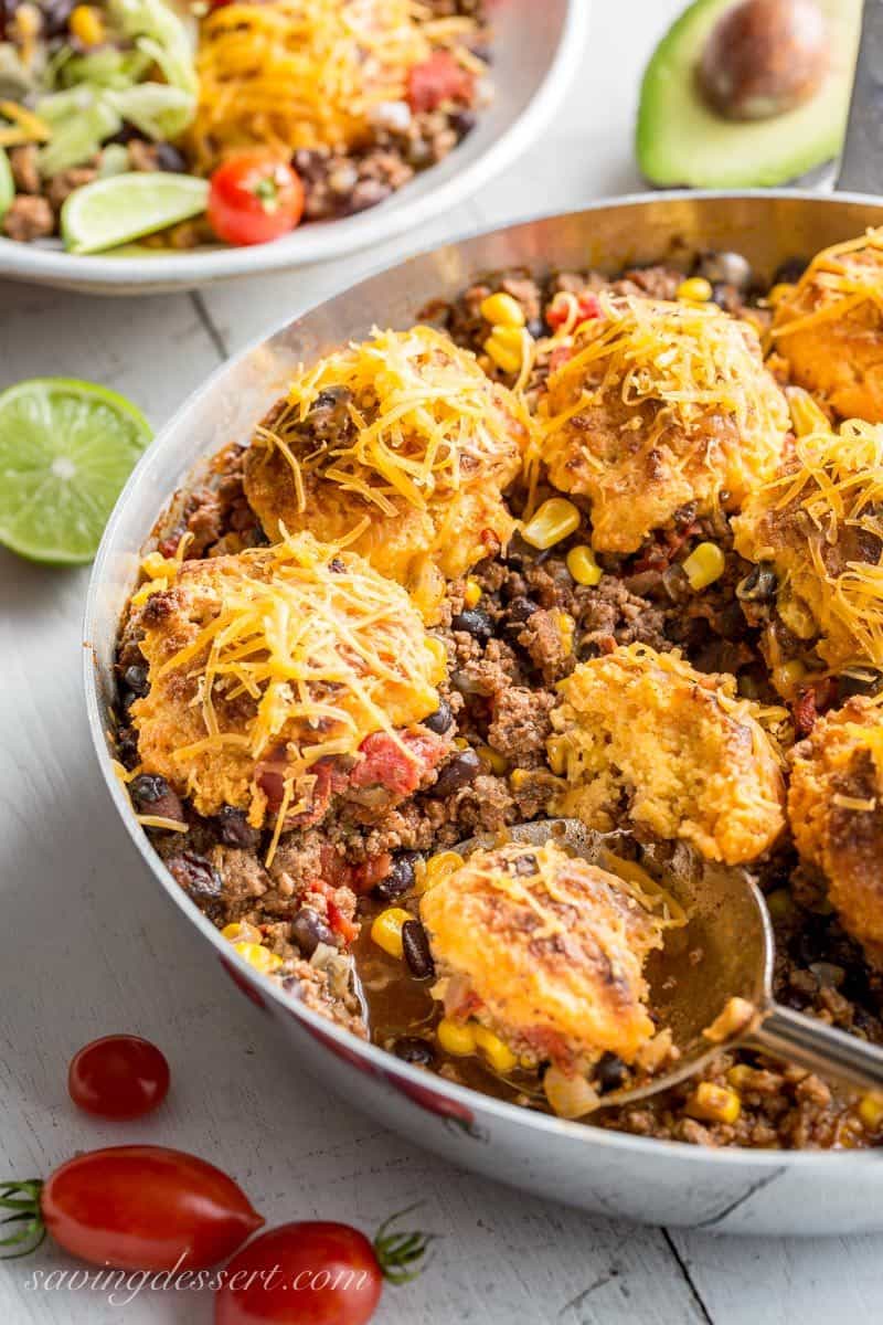 Skillet Taco Cobbler ~ ground beef, black beans, tomatoes and corn come together in a nicely spiced base for our tender, cheesy cornmeal biscuits. www.savingdessert.com #savingroomfordessert #cobbler #taco #tacocobbler #cornmealbiscuits