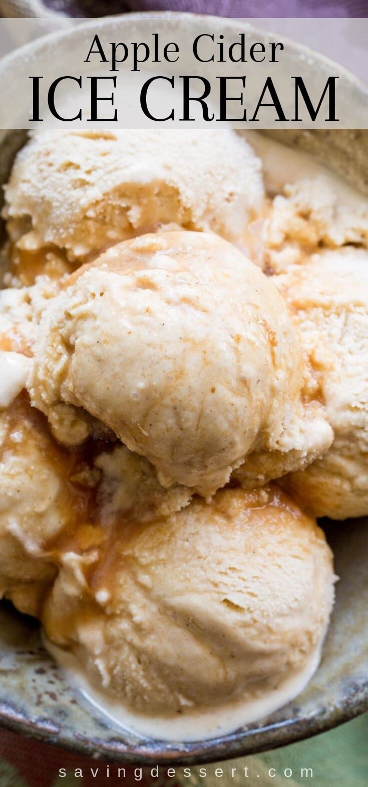 A closeup of a bowl of ice cream scooped into a pile with a drizzle of syrup over the top