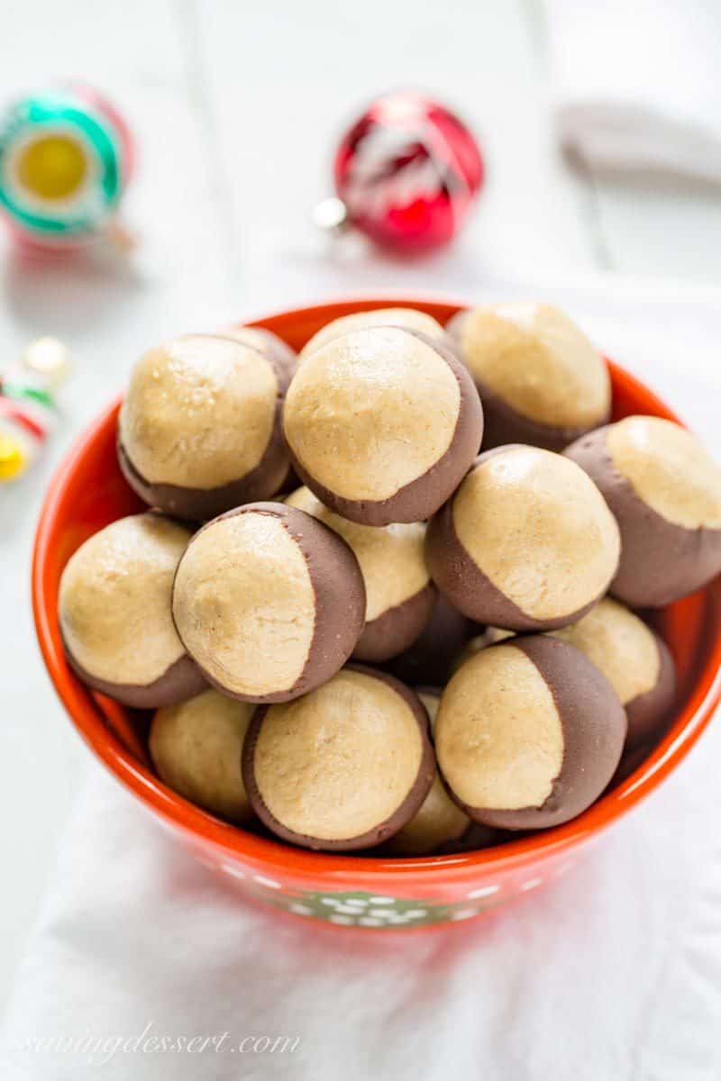 Peanut Butter Buckeye Candy ~ creamy, sweet peanut butter dough balls are partially dipped in chocolate to mimic the fruit of the Ohio Buckeye tree. www.savingdessert.com #savingroomfordessert #buckeyes #peanutbutterballs #christmascandy #buckeye