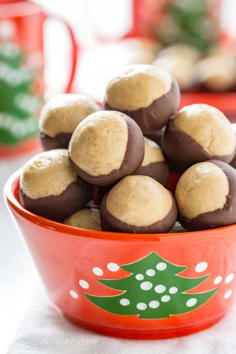 Peanut Butter Buckeye Candy ~ creamy, sweet peanut butter dough balls are partially dipped in chocolate to mimic the fruit of the Ohio Buckeye tree. www.savingdessert.com #savingroomfordessert #buckeyes #peanutbutterballs #christmascandy #buckeye