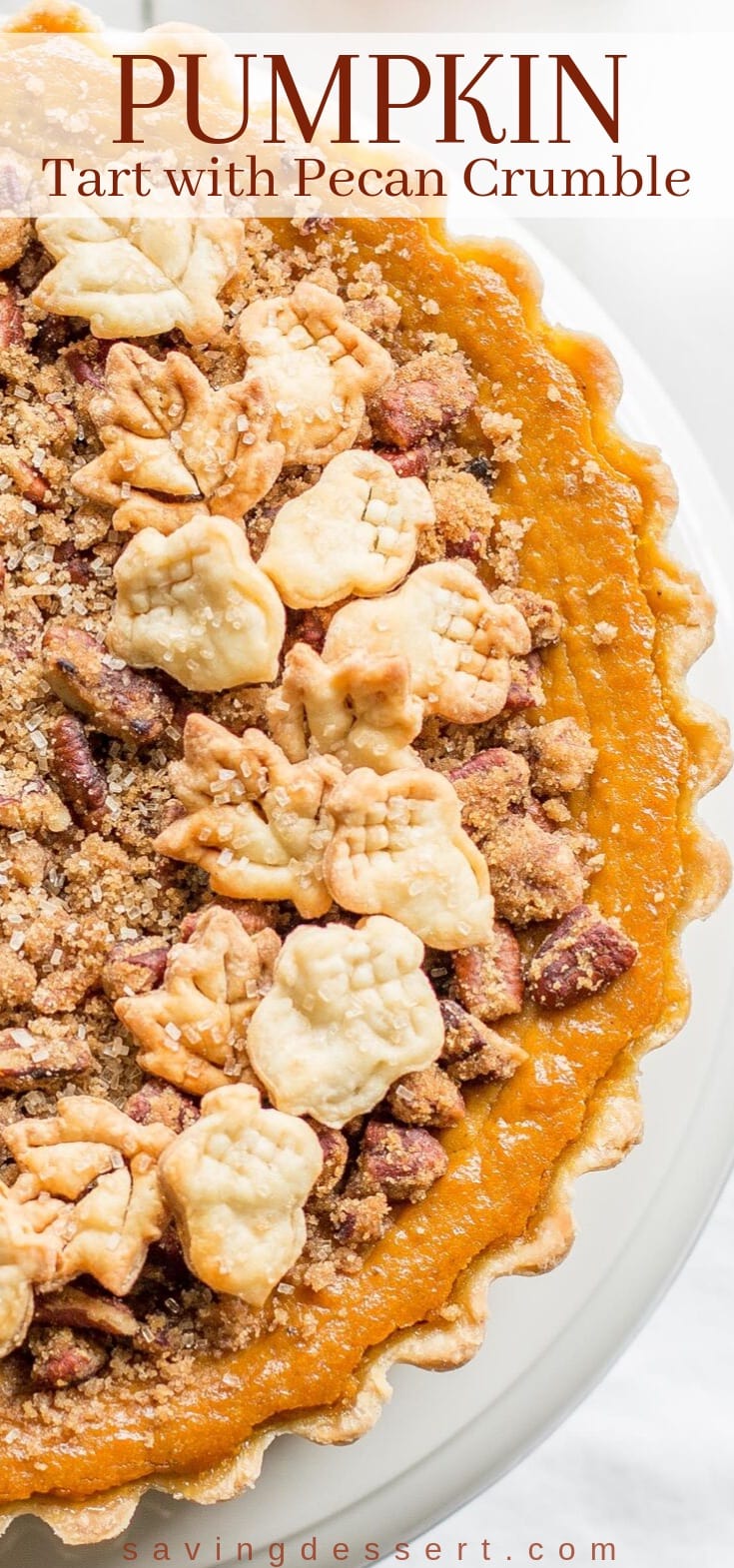 An overhead view of a pumpkin tart with a pecan crumble and pie crust cookies on top