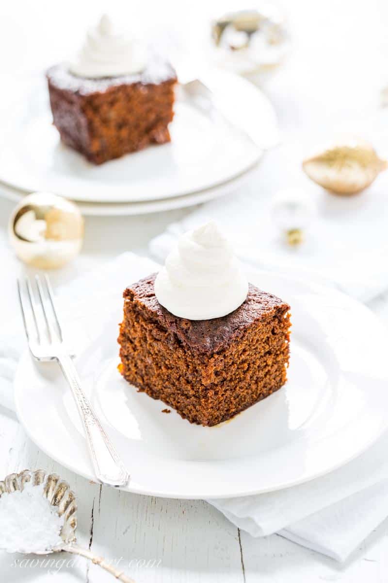 Gingerbread cake on white plates with lemon whipped cream on top