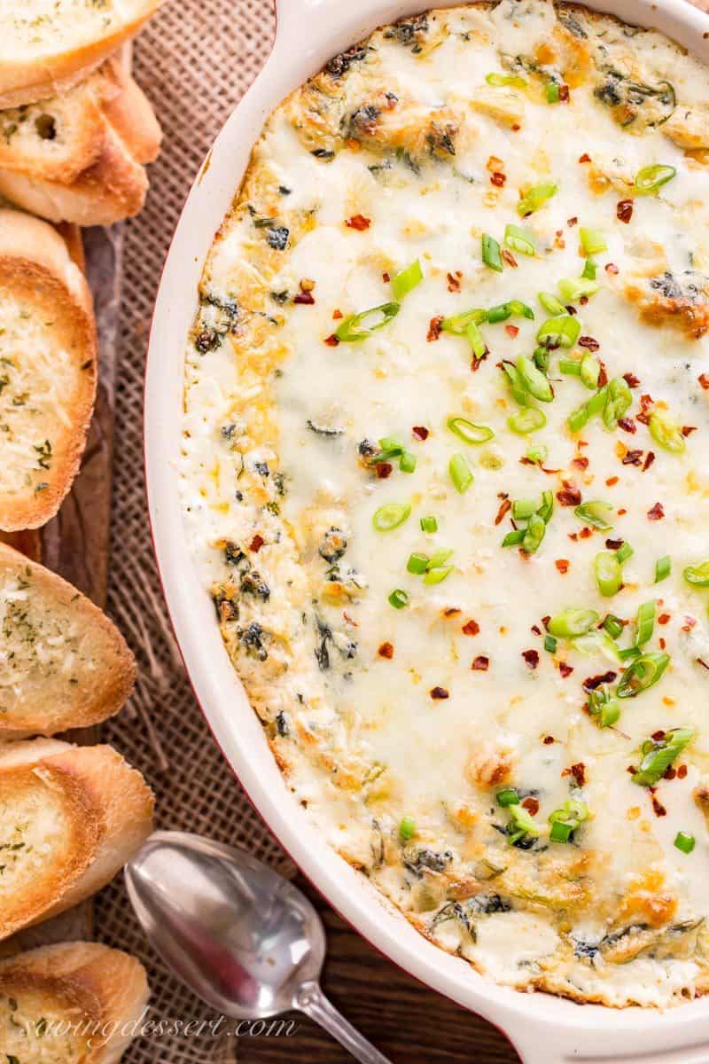 Hot Spinach and Artichoke Dip - Cheesy, creamy and loaded with chunks of artichoke hearts, earthy spinach, garlic and sweet onion. Serve with your favorite toasted baguette slices, crackers or chips for a memorable appetizer hearty enough to feed a hungry crowd - with easy make ahead directions too! #savingroomfordessert #spinachartichokedip #hotspinachdip #artichokedip #appetizer #hotappetizer #dip #hotdip