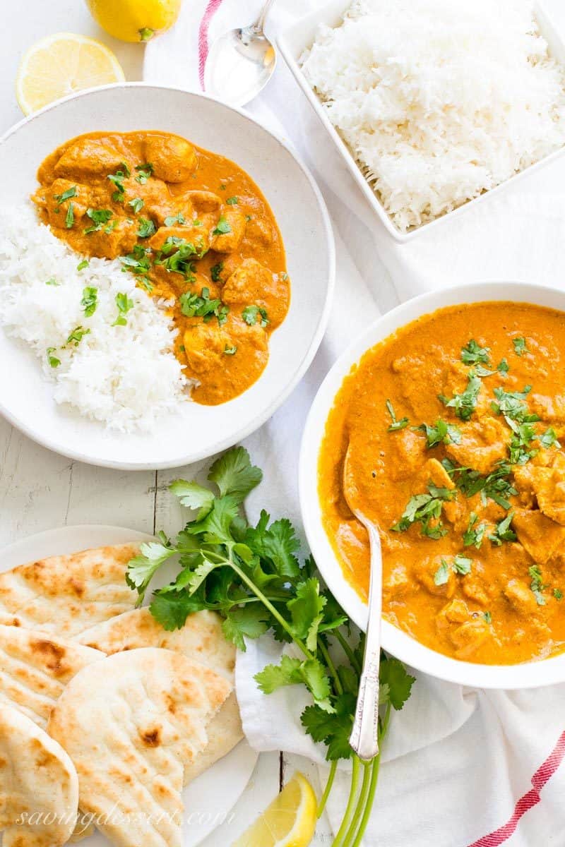 Indian Butter Chicken Recipe served with hot Basmati rice and naan bread, garnished with cilantro