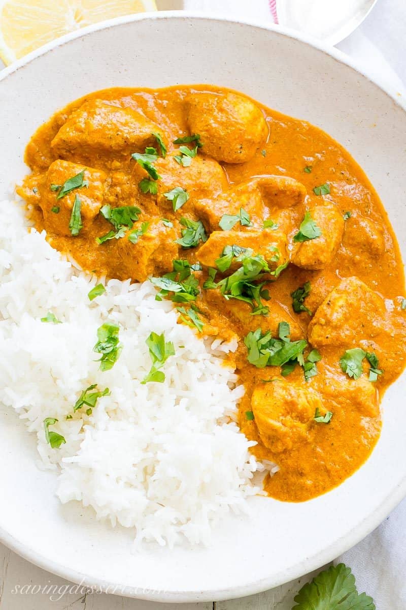 Indian Butter Chicken Recipe served with hot Basmati rice and naan bread, garnished with cilantro