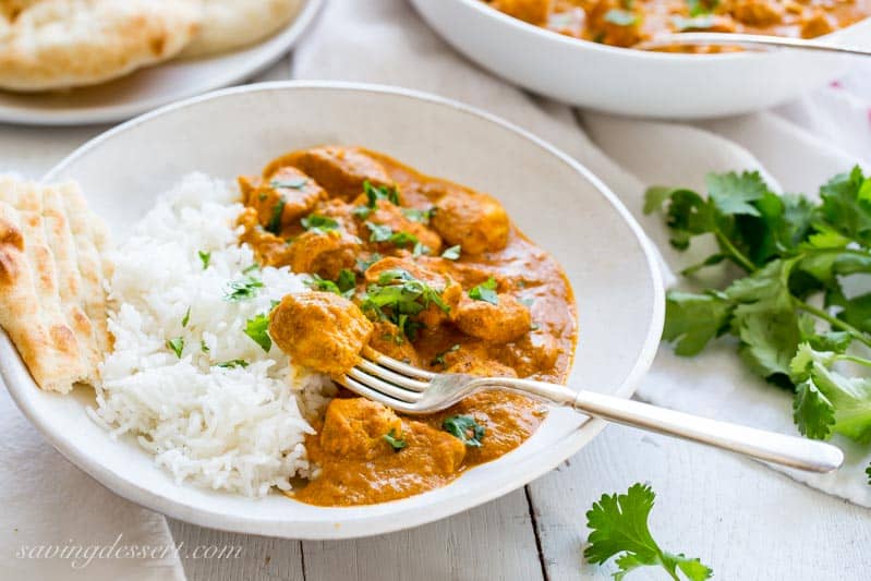 Indian Butter Chicken Recipe served with hot Basmati rice and naan bread, garnished with cilantro