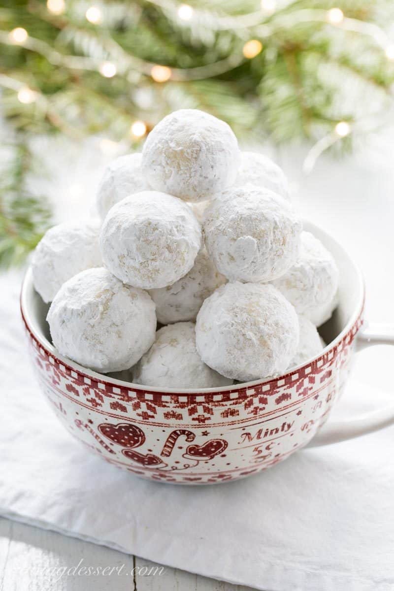 A bowl of powder sugar covered cookies called Russian Tea Cakes
