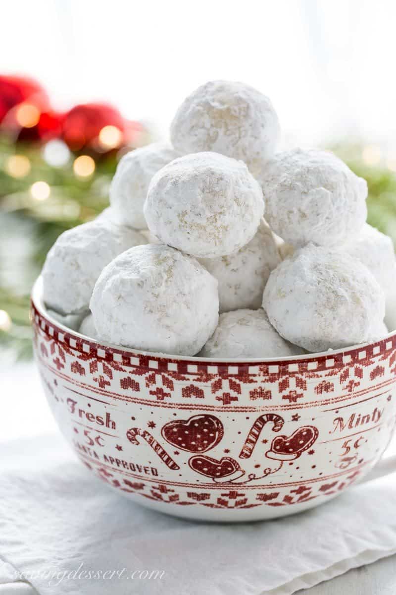 A bowl of Russian tea cake cookies covered in powdered sugar