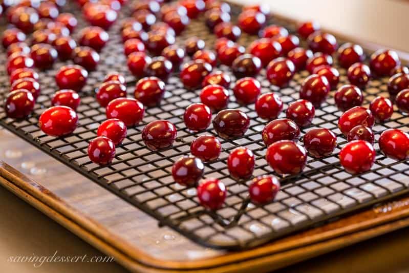 A cooling rack covered with cranberries that have been dipped in a simple syrup
