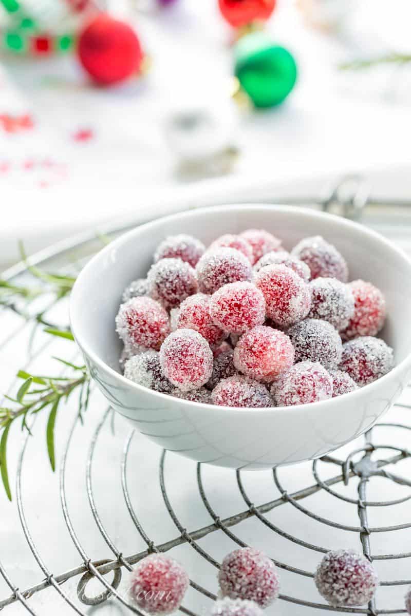 A small bowl of sugared cranberries with rosemary